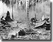 Wreckage of a US scout/bomber still burning after a Japanese air attack on Henderson Field